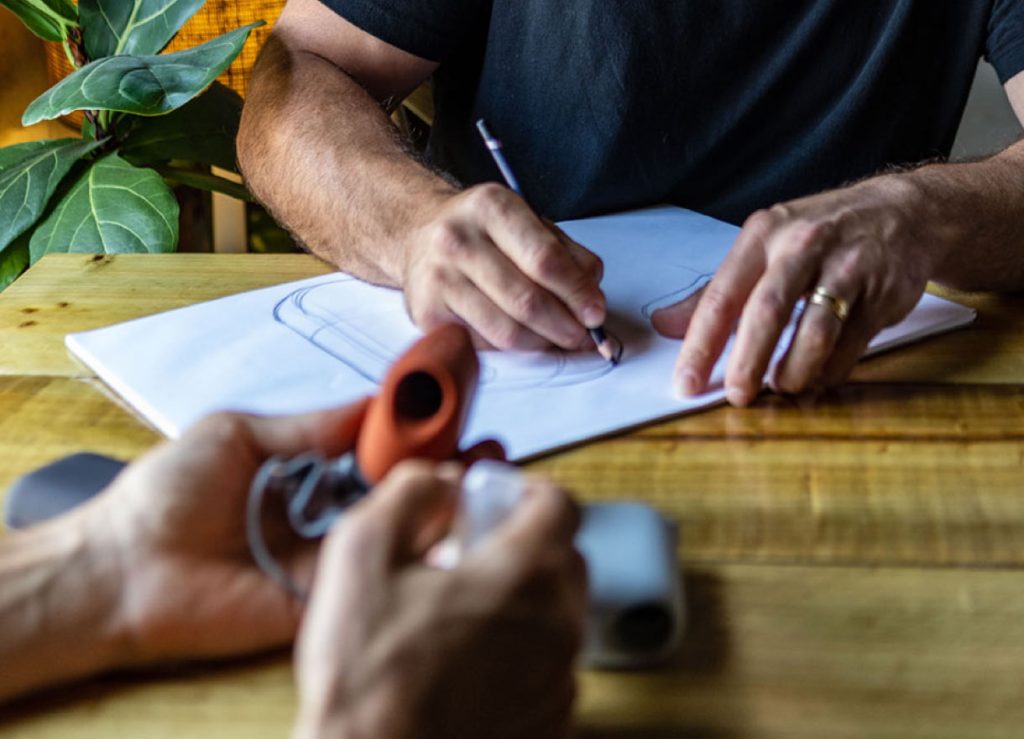  A closeup of our hands as we redesign and take notes on a product we’re prototyping.